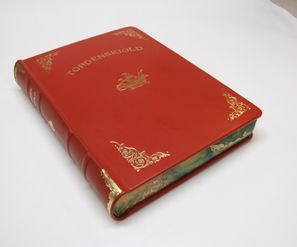 Håndbunnet bok i rødt lær